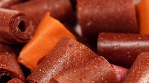 Closeup top view video footage of tasty healthy homemade organic dessert made of different kinds of fruits. Rolls of dried fruit leather perfect for eating as healthy snack. 