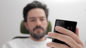 appearing in depth of field, the man negative and callous makes video calls with his smart phone