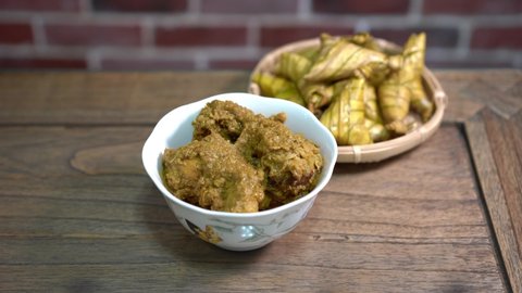 Cinematic shot of ketupat palas and chicken rendang, traditional malay cuisines typically served during eid