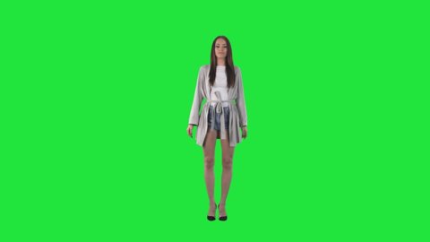 Confident modern stylish fashion model girl with cardigan posing with attitude. Full body isolated on green screen chroma key background