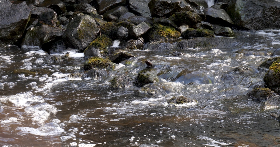 Stream goes over black stones