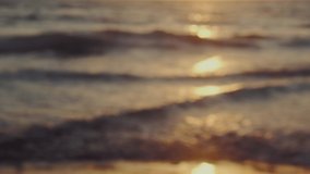 Beautiful defocused abstract golden blurry sea water background. soft waves of the Mediterranean Sea with soft reflection of the light of the sunset sun