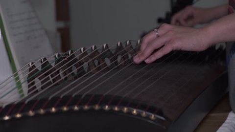 Close up of playing Chinese music instrument Guzheng by online class at home amid coronavirus pandemic