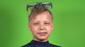 Closeup view 4k video portait of cute happy smiling kid wearing snorkeling mask standing isolated on green background.