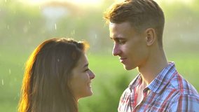 2 in 1 video! The couple stand, smile and kiss by the summer rain background. Slow motion capture. Shot with Red Cinema Camera