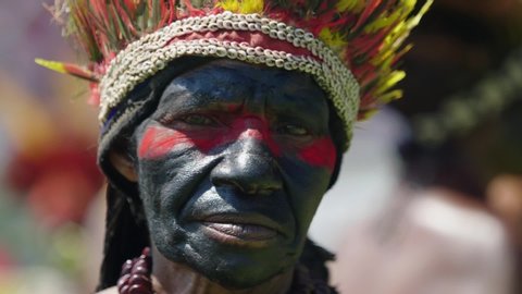 kanganama , Oceania / Papua New Guinea - 09 11 2019: Extreme close up shot, tribeswoman face cover in black paint and red paint on the eyes.