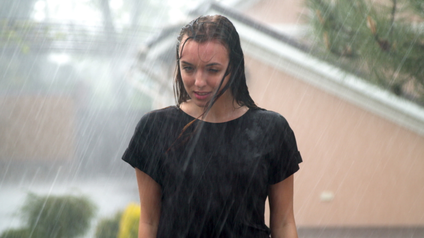 Young woman enjoying rain in garden