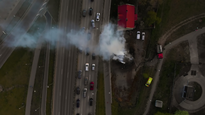House burns and smokes at highway. Firefighters finish extinguishing fire aerial
