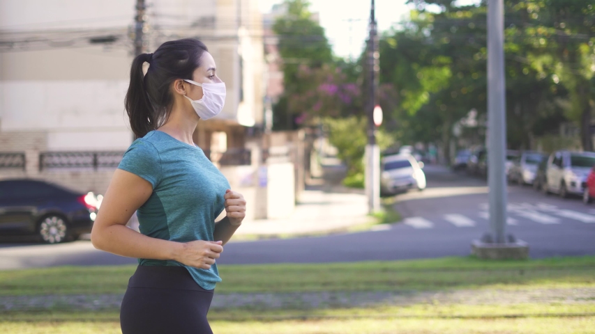 Portrait of young and fit woman running and jogging alone on the empty street in city center wearing protective face mask
 Royalty-Free Stock Footage #1052155354