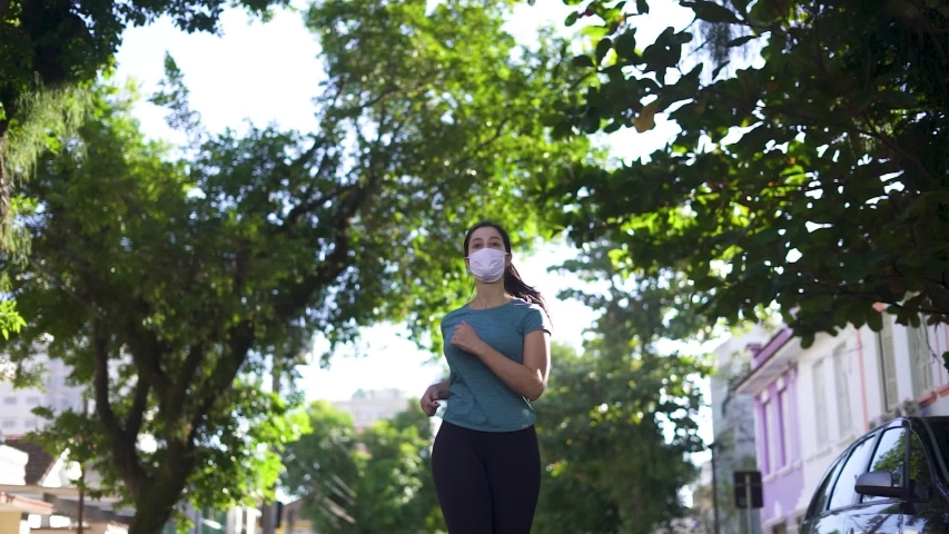 Portrait of young and fit woman running and jogging alone on the empty street in city center wearing protective face mask
 Royalty-Free Stock Footage #1052155474