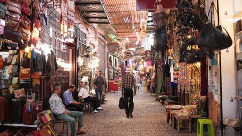 MARRAKESH, MOROCCO- JUNE, 11, 2019: gimbal stabilized clip walking along a narrow alley past souks and vendors at marrakesh, morroco