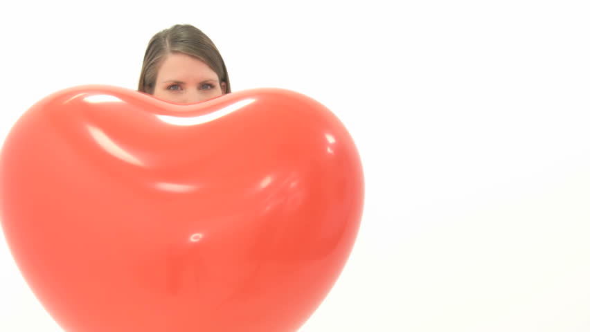 Woman lets heart balloon fly and crosses her arms