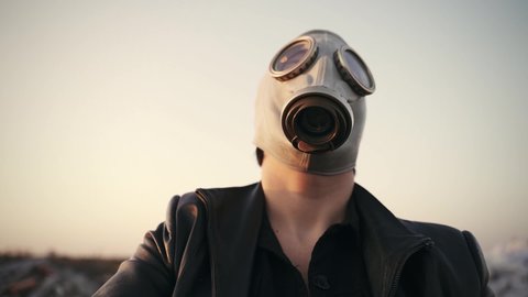 portrait of a man in a gas mask and a black jacket who plays the piano