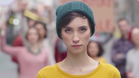 Portrait of confident woman in march fighting for freedom. Young latin woman empowerment strike on street. Casual girl in march to protest on equality rights. Happy smiling woman looking at camera. - Powered by Shutterstock - Get 15% off with code: PIKWIZARD15