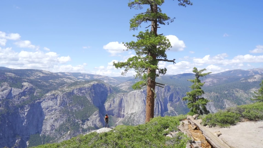 A young woman in Sentinel Dome looking at Upper Yosemite Fall, Yosemite National Park. United States