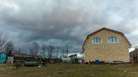 House under cloudy sky. 4k timelapse.
