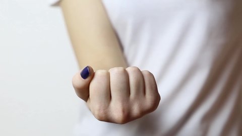 Closeup of hands with classic blue manicure showing middle finger in "fuck off" gesture