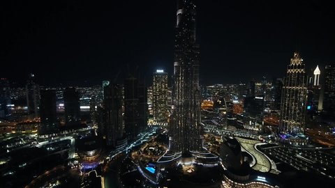 Dubai, United Arab Emirates - 12/31/2019 : Pull back reverse shot with panning on the Burj Khalifa glowing with the entire beautiful city, drone shot. 