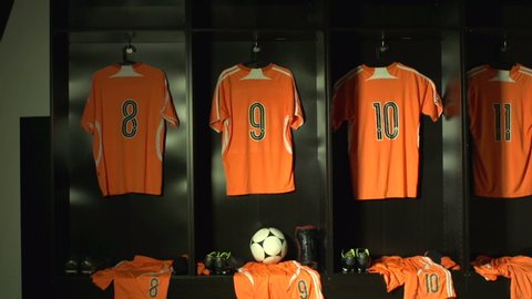 Soccer /  Football Changing room / Locker room. All the kit or uniform is laid out ready for the players. Unbranded ball. Tracking Shot Towards. Stock Video Clip Footage