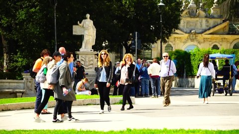 Rome, April 25, 2019: Tourists stroll in the gardens near the entrance to the Roman museum of the BORGHESE GALLERY, with works by Bernini, Canova and Michelangelo