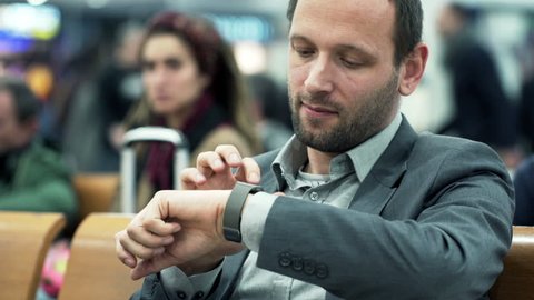 Young businessman using smartwatch while sitting at train station

