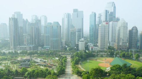 JAKARTA - Indonesia. April 29, 2020: Aerial view of skyscrapers with quiet traffic on road during coronavirus quarantine in Jakarta city. Shot in 4k resolution
