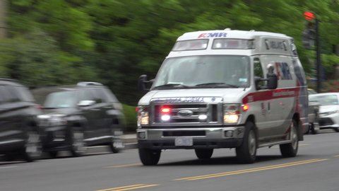 WASHINGTON, DC - MAY 8, 2020: AMR ambulance passes fast, siren, lights.  AMR supplements the city's DC Fire and EMS Department.