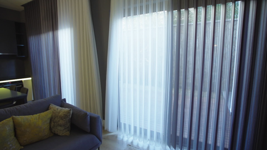 Automatic curtains open in the living room and the garden looks. Royalty-Free Stock Footage #1052249446