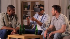 friendship, technology and gaming concept - male friends with vr glasses and gamepad playing video games at home at night