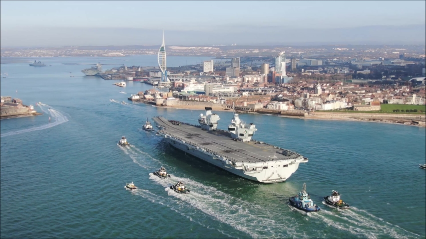Portsmouth , Hampshire / United Kingdom (UK) - 12 04 2019: HMS Queen Elizabeth arriving into Portsmouth under tug and tow. Spinnaker tower and HMS Prince Of Wales in background. First meeting. Southse
