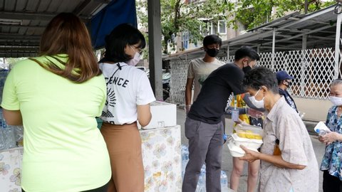 May 2020, Bangkok, Thailand. While the Covid-19 virus still spreading, the philanthropist give food​ to those affected. Also with staff​ to facilitate and take care of everyone to wear a mask.