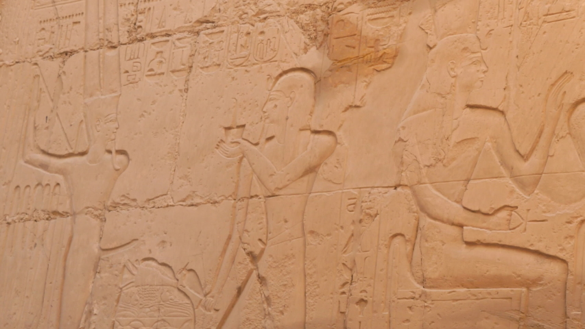 Image of the Pharaoh is on the Wall of the Karnak Temple. Pharaoh Stands Manly With a Crown on His Head and the Slave Stands Beside. Goddess Holding an Ankh in Her Hands is a Symbol of Eternal Life.