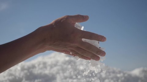 raw salt crystals in hands. Male hand holding natural salt crystals on the background of a salt lake. White natural salt. natural resources concept,