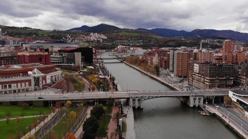 Bilbao Spain aerial shot. City center, old houses, river, bridge, mountains on the background, new Bilbao, Europe, drone video.