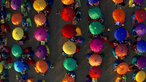 Colourful beach umbrellas and people enjoying the summer in Seminyak beach. 15 January 2020: Bali, Indonesia.