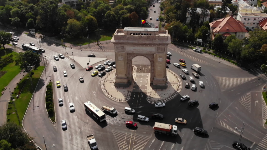 Arc de Triomphe Bucharest Romania aerial shot. Beautiful raid on a drone over the arch. Traffic, cars, traffic in a circle, trees, architectural monument, Europe