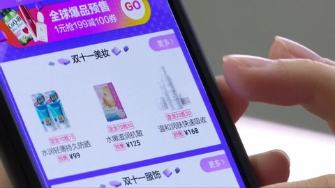 Shenzhen / China - 07 04 2018: Close up shot of female person shopping online with smartphone in chinese online shop