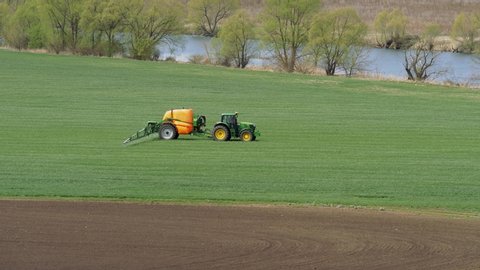 April 03, 2020 - EDITORIAL - village of Zhilino, Oryol region, Russia: AMAZONE. Sowing, processing of fields. Pest control. The Amazone trailer sprayer is in operation. Green field of wheat shoots.