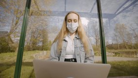 Woman in face mask listens to online webinar conference