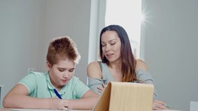 Mother with her son studying online at home