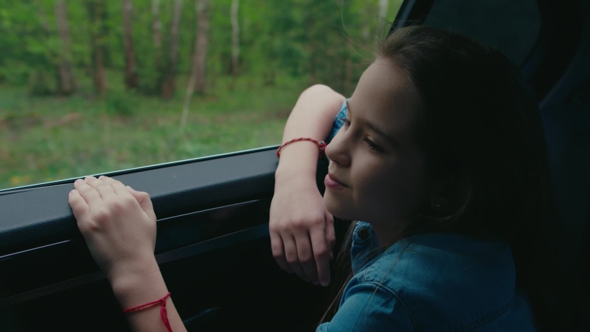 girl travelling by car, opens window to breathe fresh air of countryside Royalty-Free Stock Footage #1052346082