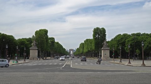 France, Paris - May 11 2020: Traffic on Champs-Elysees with Arc de Triomphe in background, from place de la Concorde. Traffic is low because of lockdown due to Covid-19.