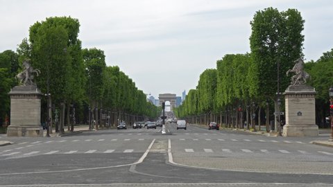 France, Paris - May 11 2020: Traffic on Champs-Elysees with Arc de Triomphe in background, from place de la Concorde. Traffic is low because of lockdown due to Covid-19.