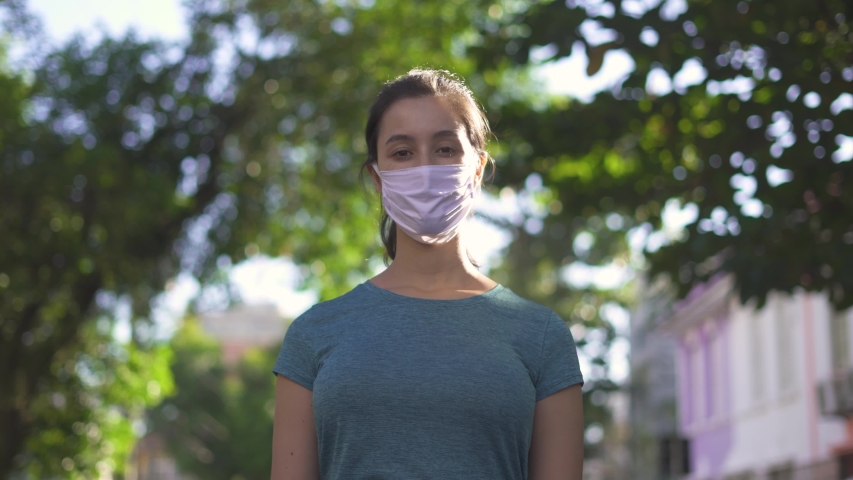 Portrait of young woman alone on the empty street in city center wearing protective face mask
 Royalty-Free Stock Footage #1052358571