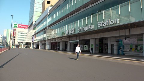 TOKYO, JAPAN - APRIL 2020 : View around Shinjuku station. Tokyo governor called refrain from going outside, due to concerns over Coronavirus. Street is normally busy, but lightly populated.