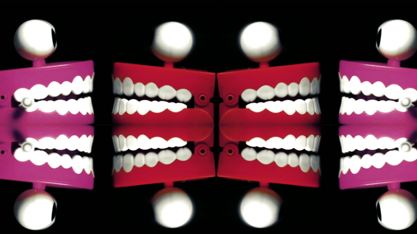 lots of chattering teeth on black and reflection 