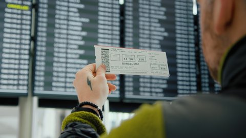 Citizen try to return home. Traveller or tourist search for cancelled or delayed flight on information screen in airport. Vacation or summer holiday cancellation. Suspended flights to spain, barcelona