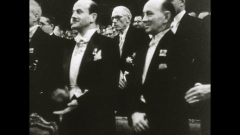 1960s: King Gustav presents Enrico Fermi with Nobel Prize, pan to crowd applauding.