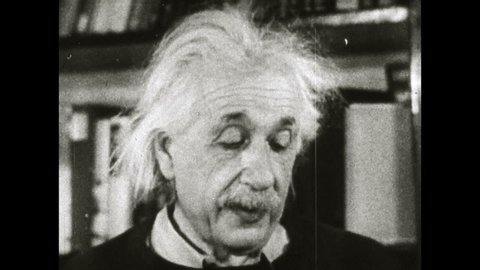 1960s: Close up of Albert Einstein talking. Einstein at desk, reading letter.