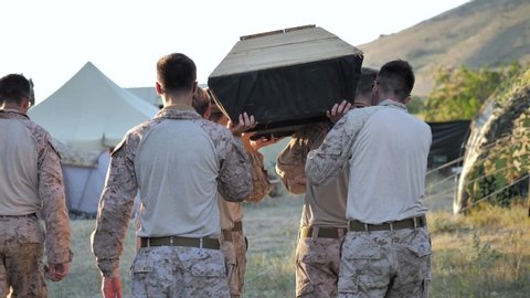 Airsoft. Military camp. Funeral of a friend. The coffin is carried on the shoulders of soldiers.